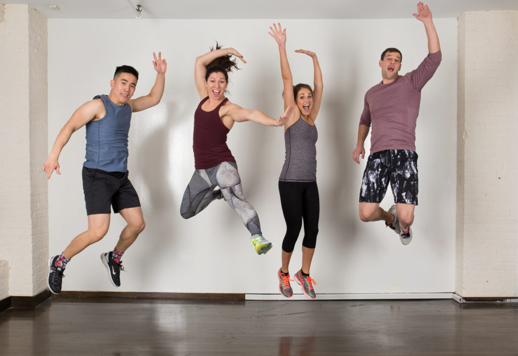 Four people jumping in fitness studio