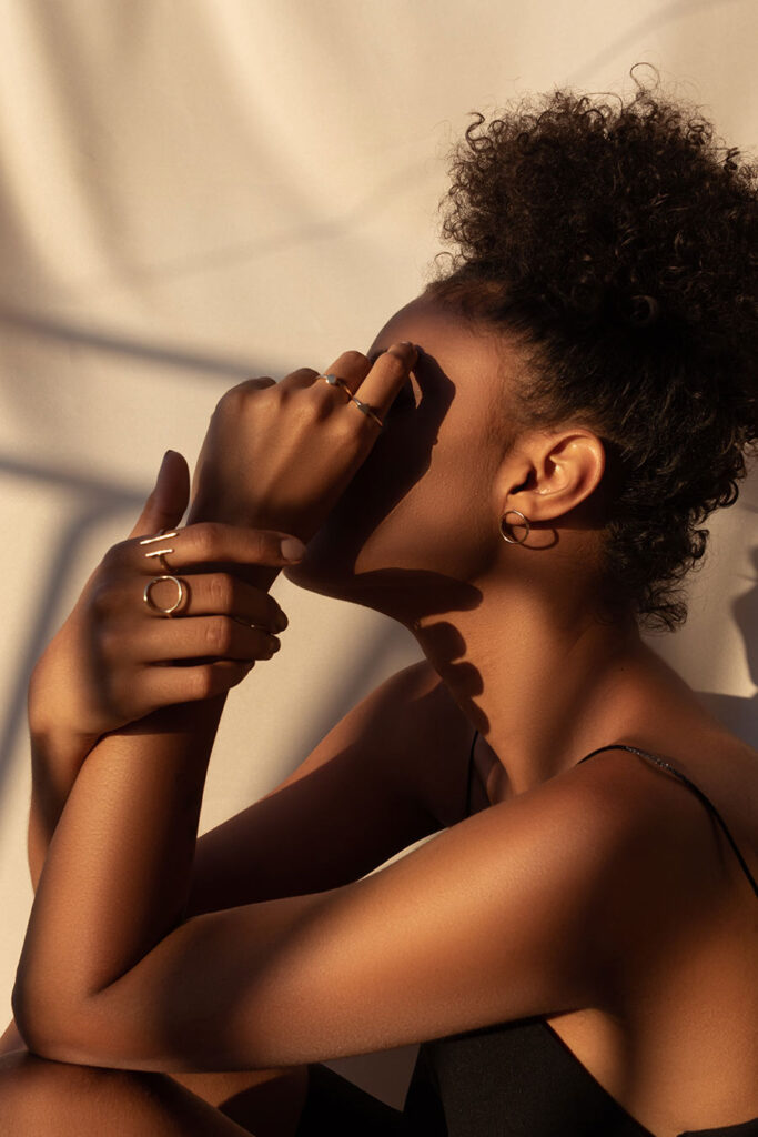 Woman shielding face in warm sunlight