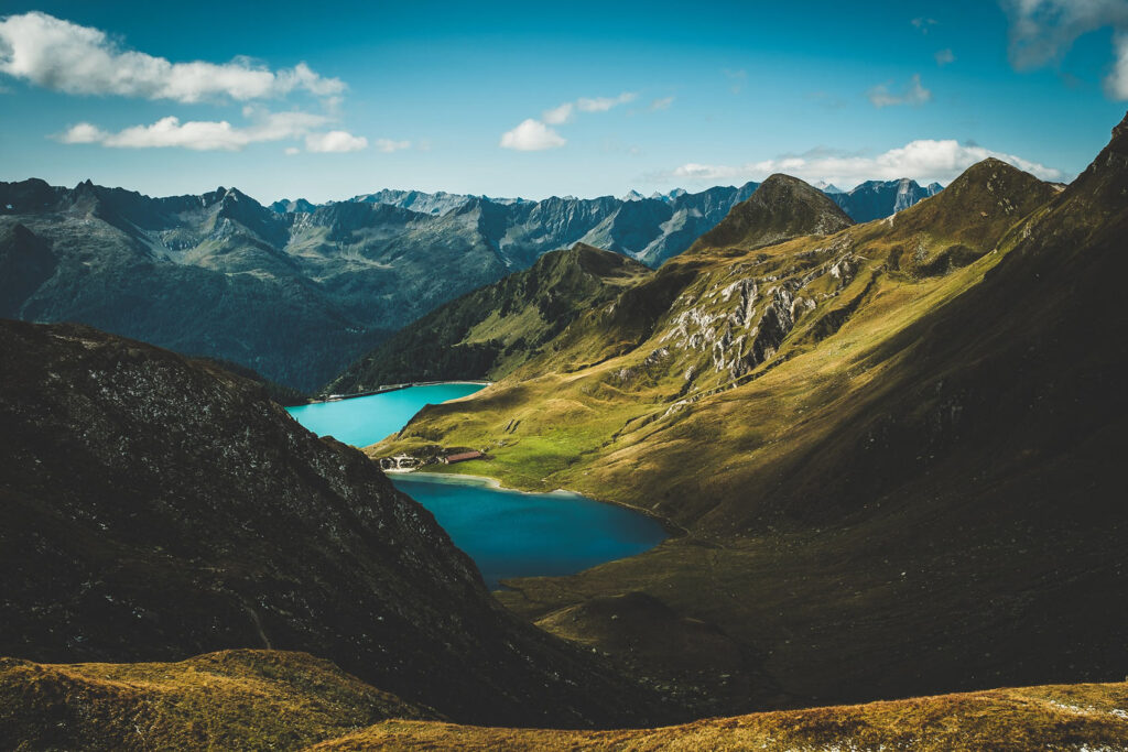 Turquoise alpine lake surrounded by green mountains