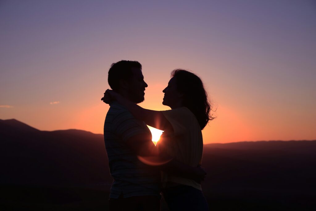 Couple hugging back lit by sunset. Photo by Oziel Gómez on Unsplash
