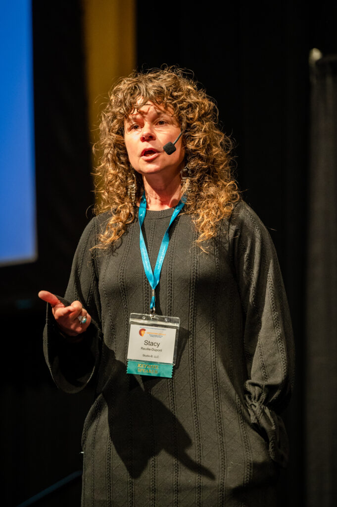 Curly-haired woman speaking on stage