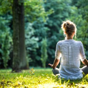woman meditating in forest