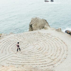 Man walking labyrinth on beach