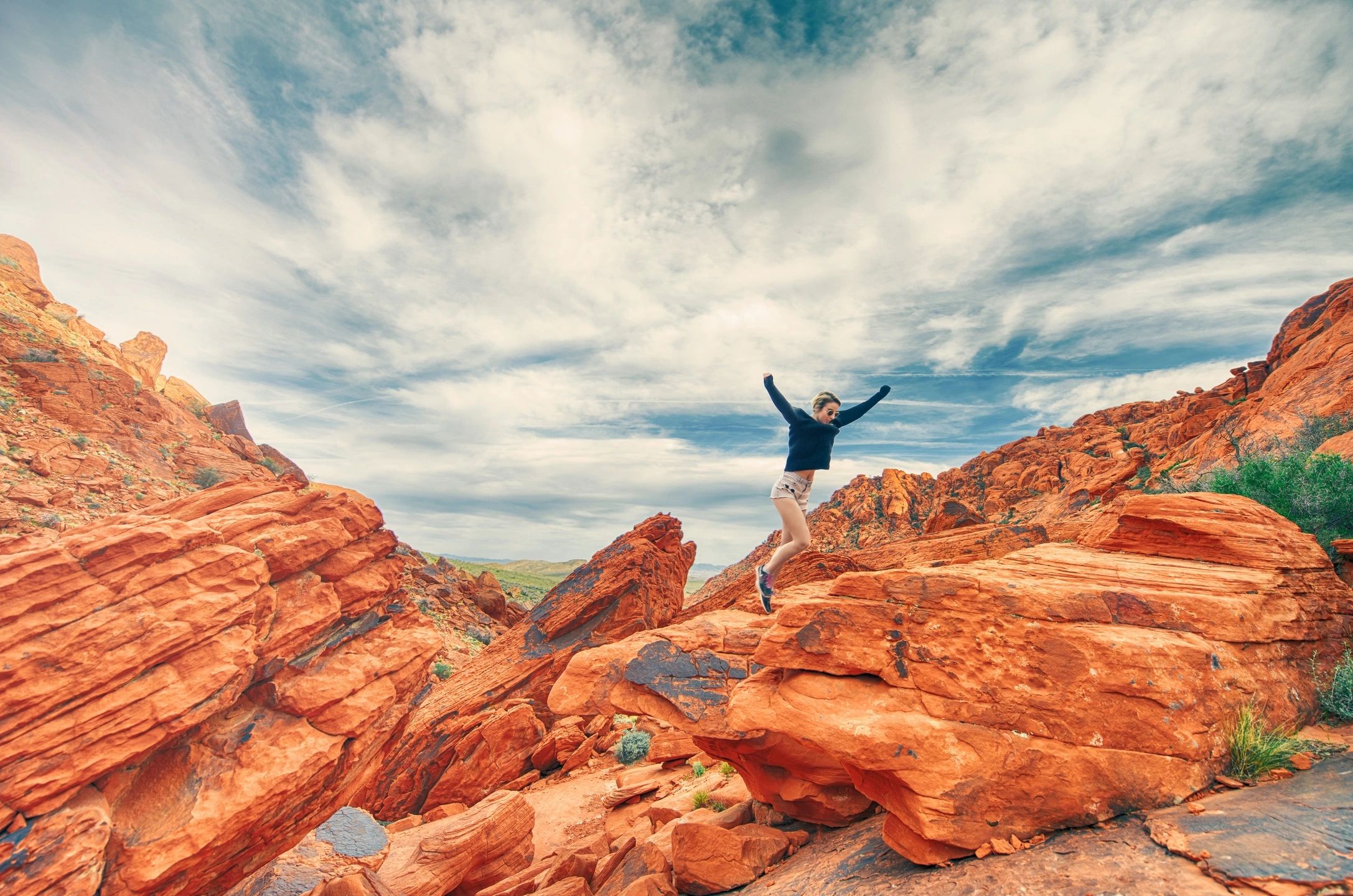 qtq80-4pVrVZ Woman jumping over red rocks