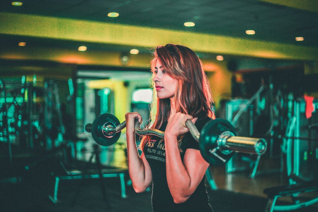 Woman lifting with curl bar in gym