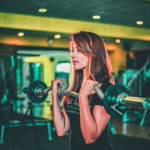 Woman lifting with curl bar in gym